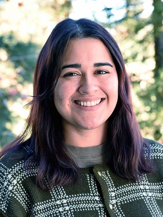 A person with shoulder-length hair and a bright smile.