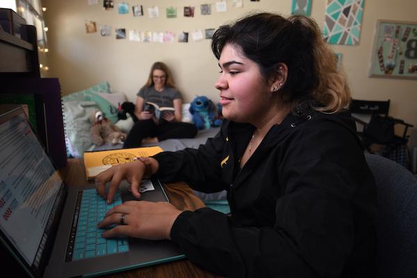 Student typing on a PC in a student dormitory