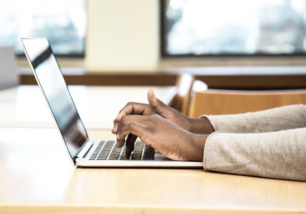 student typing on laptop