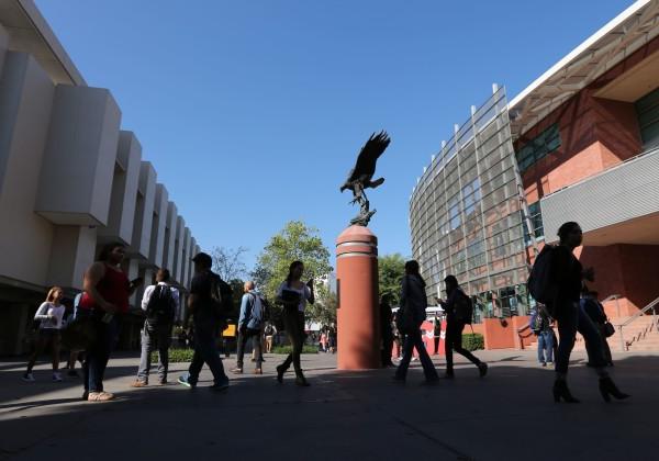 statue of golden eagle and student walking around