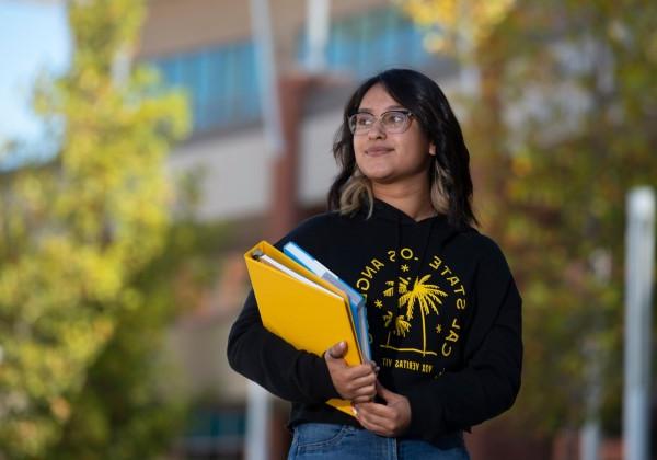 cal state LA student carrying 2 books 