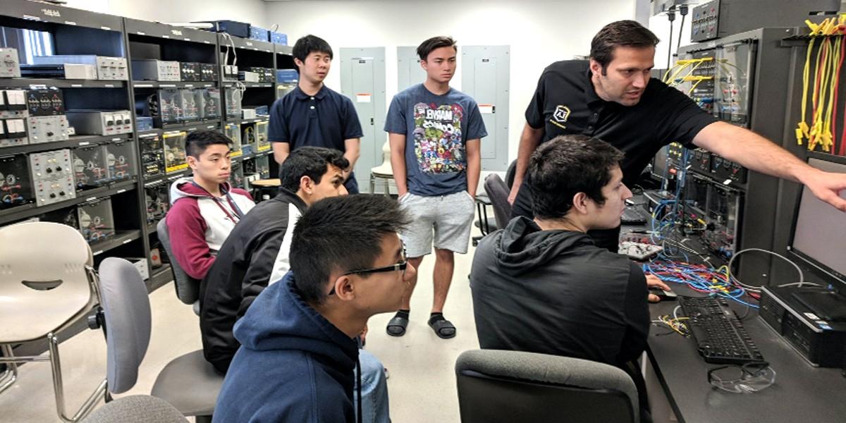 faculty and students work with electronics in lab