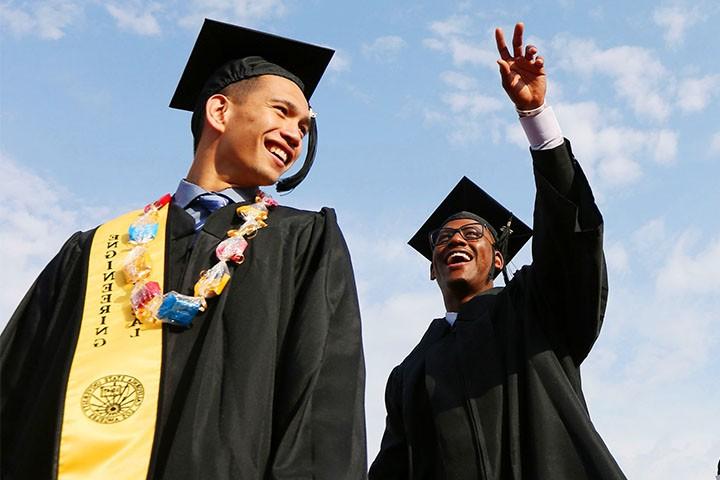 two graduates walking towards commencement