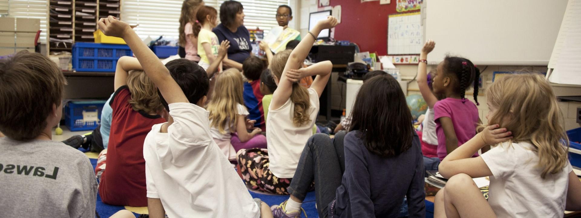 student raising hand in the classroom